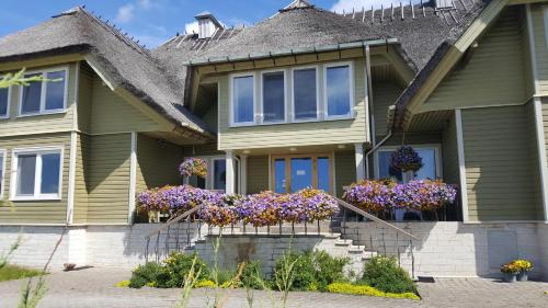 ein Haus mit Blumen auf den vorderen Stufen in der Unterkunft Altmõisa Guesthouse in Tuuru