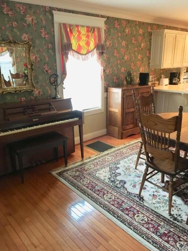 a living room with a piano and a table at Downtown abode in the heart of the Bourbon Trail in Lebanon