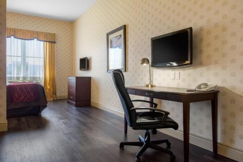 a room with a desk with a computer and a television at Comfort Inn & Suites in Lévis