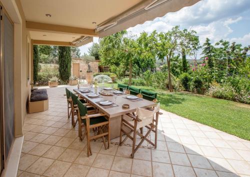 a table and chairs on a patio with a garden at Family Getaway in Marathon by GHH in Marathón