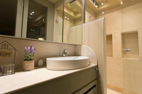 La salle de bains est pourvue d'un lavabo et d'un miroir. dans l'établissement Plaka360 Apartments, à Athènes
