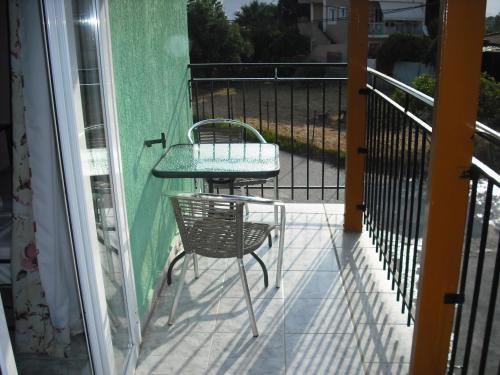 a patio with a table and a chair on a balcony at ΣΑΡΑΝΤΗΣ ΜΑΡΚΌΠΟΥΛΟς in Lakithra