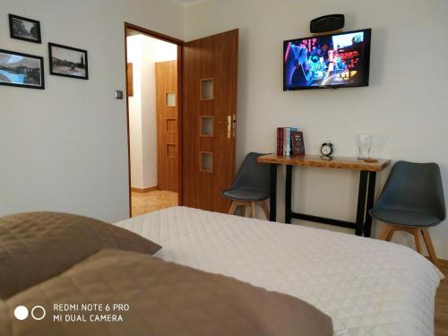 sypialnia z łóżkiem i telewizorem na ścianie w obiekcie Apartament Briesen w mieście Wąbrzeźno