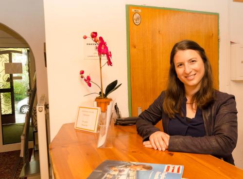 a woman sitting at a table in a room at Gästehaus Herlinde in Podersdorf am See