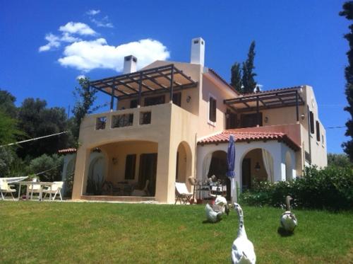 a house with chickens standing in front of it at Oneiro in Diliso