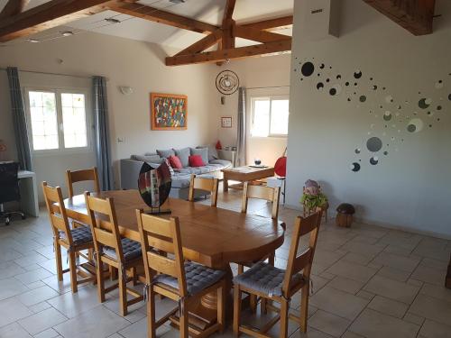 una sala da pranzo con tavolo, sedie e divano di Villa au calme dans un pittoresque petit village a Montpezat