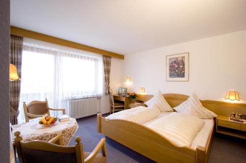 una habitación de hotel con una cama grande y una mesa en Kurhotel Dornröschen en Bad Wörishofen