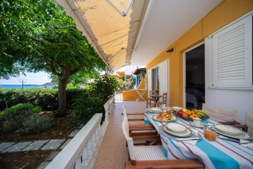 a table with plates of food on a patio at Stegnailion in Archangelos