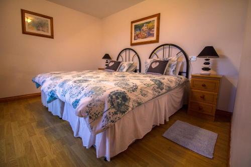 a bedroom with a bed and a dresser with a bedspread at Killoughagh House in Cushendall