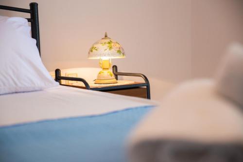 a lamp on a table next to a bed at Stegnailion in Archangelos