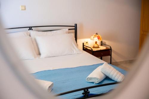 a bedroom with a bed and a table with a lamp at Stegnailion in Archangelos