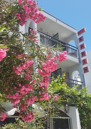 a building with pink flowers in front of it at Karis Hotel in Kos Town