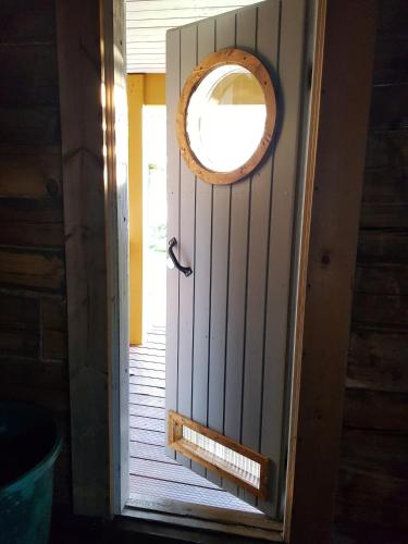 an open door with a round window on it at Salen Saunamökki in Ranua