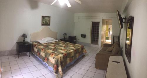 1 dormitorio con 1 cama y 1 sofá en Negril Beach Club Condos, en Negril