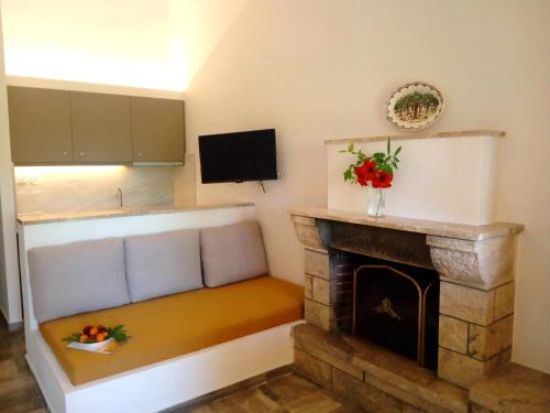 a living room with a couch with a fireplace at Studio Candia in Kandia