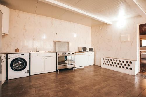 a large kitchen with a washer and dryer at Gaia Beach House in Vila Nova de Gaia