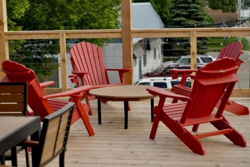 Crosby的住宿－Crosby Lofts，庭院里设有四把红色椅子和一张桌子