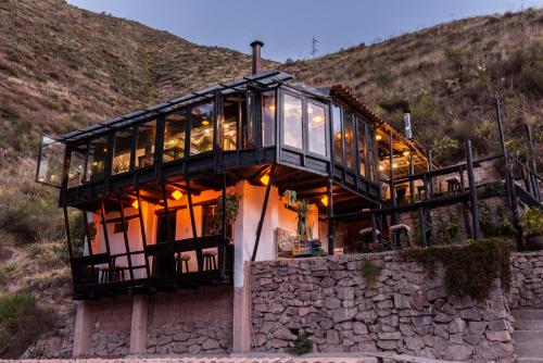 a house on top of a stone wall at Wolf Totem Steam Punk Guesthouse in Pisac