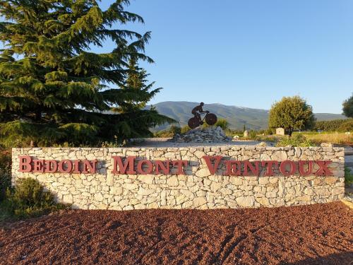 a stone wall with a sign that reads benoit memory wonders at Le Clos Marceau in Bédoin