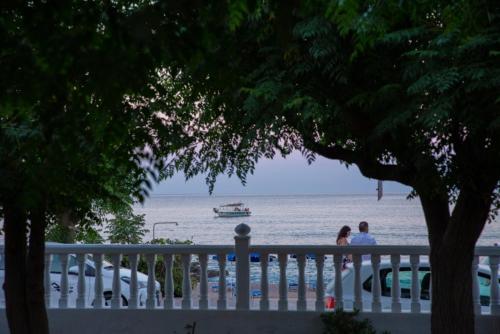 two people standing on a fence looking at the water at Stegnailion in Archangelos