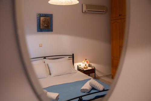 a bedroom with a bed and a mirror at Stegnailion in Archangelos