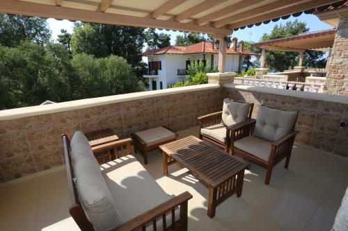 un patio con sillas, mesas y una pared de ladrillo en Villa Argo 3 - Beachfront, Big gardens, Location! en Pefkohori