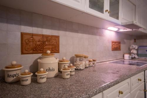 a kitchen counter with a bunch of cups on it at Stegnailion in Archangelos