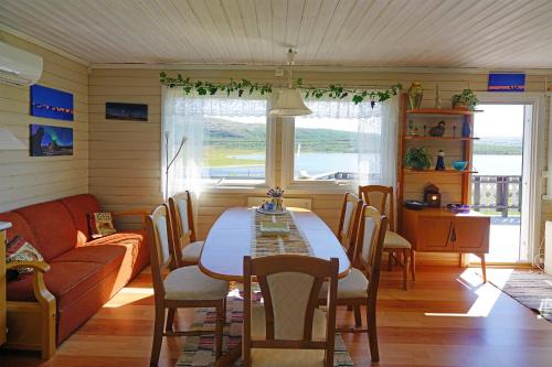 a living room with a table and a couch at Rivdnji Holiday Home Smørfjord in Russenes