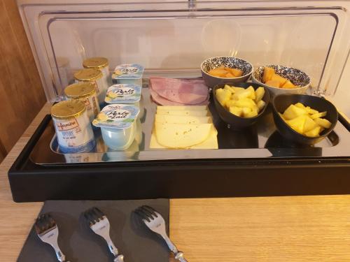 a refrigerator filled with cheese and other food items at Le Clos Marceau in Bédoin