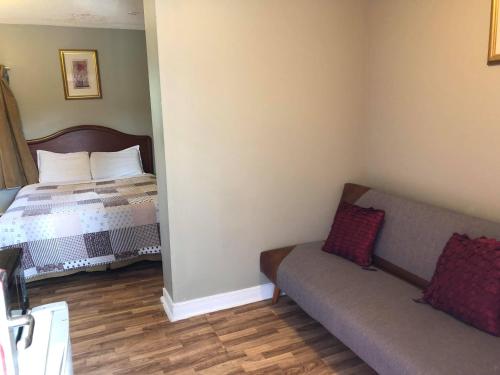 a small room with a bed and a couch at Niagara Inn & Suites in Niagara Falls