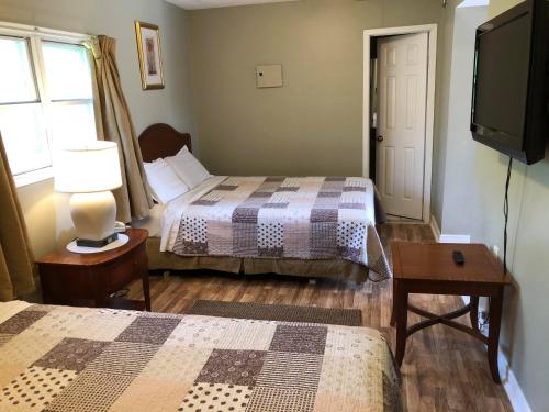 a hotel room with two beds and a television at Niagara Inn & Suites in Niagara Falls