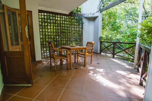 a patio with a table and chairs on a balcony at Village Ridge Boutique Stays in Pretoria