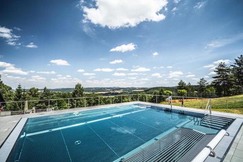 a swimming pool with a view of the countryside at Hotel Monínec in Moninec