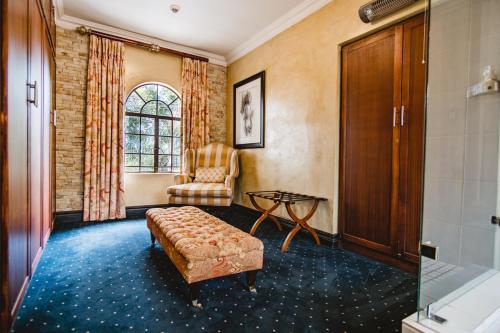 a living room with a couch and a chair at Village Ridge Boutique Stays in Pretoria