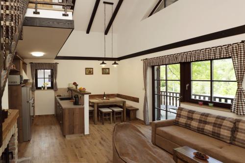 a living room with a couch and a table at Gorska bajka - Smreka, kuća za odmor i wellness in Stara Sušica