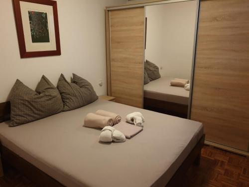 a bedroom with a bed with towels and a mirror at Apartman Max in Sveti Ivan Zelina