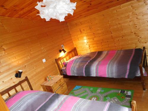 Cette chambre en bois offre une vue de tête sur deux lits. dans l'établissement Chalet Le Vintage, à La Bresse