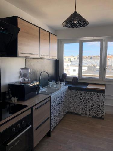 une cuisine avec un évier et une cuisinière four supérieur dans l'établissement UNE PAUSE SUR LA CÔTE, à Boulogne-sur-Mer