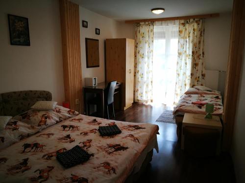 a bedroom with two beds and a desk and a window at Penzión Monty Ranch Vysoké Tatry Štôla in Štôla