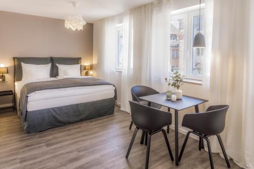 a bedroom with a bed and a table and chairs at cosy grey apartments in Freiburg im Breisgau