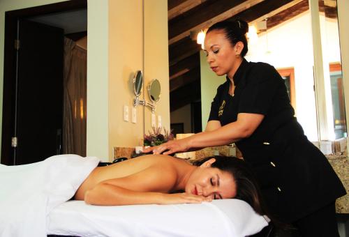 a woman laying on a bed in a spa salon at Plaza Gallery Hotel Boutique in San Cristóbal de Las Casas