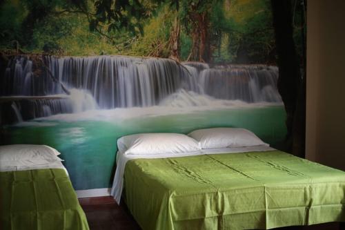 a bedroom with a waterfall mural on the wall at LA CASA DELL'ORSO in Ciampino