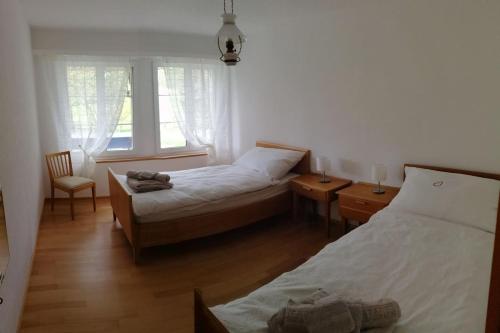 1 dormitorio con 2 camas y 2 ventanas en a casa, en Thalheim