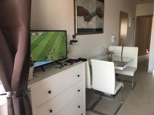 een woonkamer met een televisie op een dressoir met 2 stoelen bij Nin Ždrijac 2 in Nin
