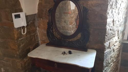 a mirror sitting on top of a bench in a bathroom at Suites storica in Palazzo antico del 1858 in pieno centro in Agnone