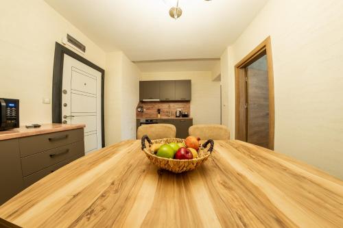a basket of fruit on a wooden table in a kitchen at Sofia Crown Life Apartment in Sofia