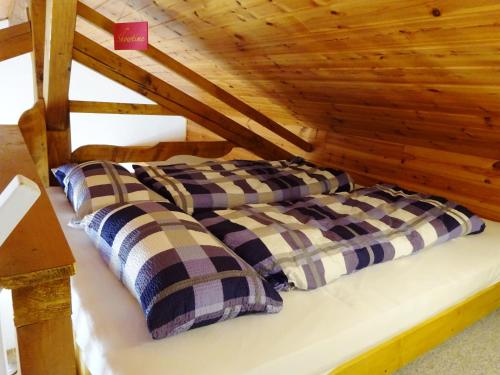 2 łóżka w pokoju z drewnianym sufitem w obiekcie Ferienwohnung Pickert w mieście Bad Endorf