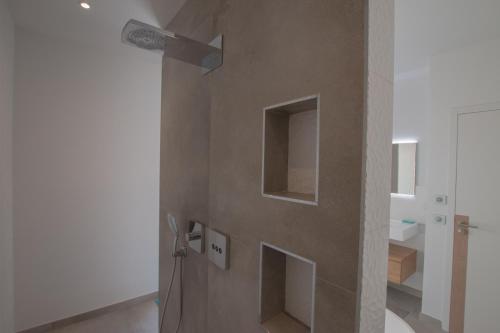 une salle de bains avec un mur doté d'une fenêtre et d'un interrupteur dans l'établissement Villa Les Colles, à Châteauneuf