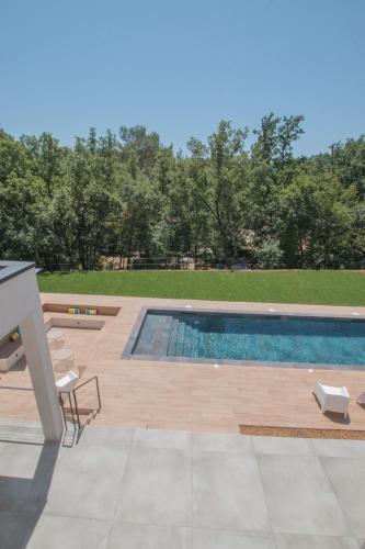 une terrasse avec une piscine, une table et des chaises dans l'établissement Villa Les Colles, à Châteauneuf