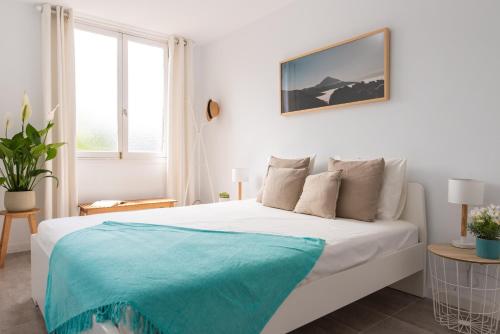Un dormitorio blanco con una cama con una manta azul. en HomeForGuest BEACH APT WITH SEA VIEW & POOL, 50 STEPS TO THE SEA, en Playa Fañabe